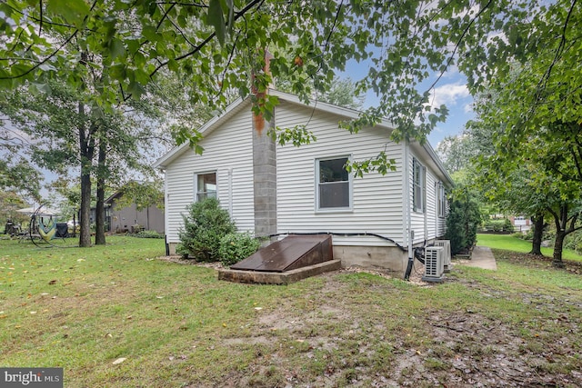 rear view of property featuring a yard and ac unit