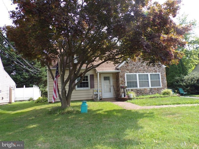 view of property hidden behind natural elements featuring a front yard