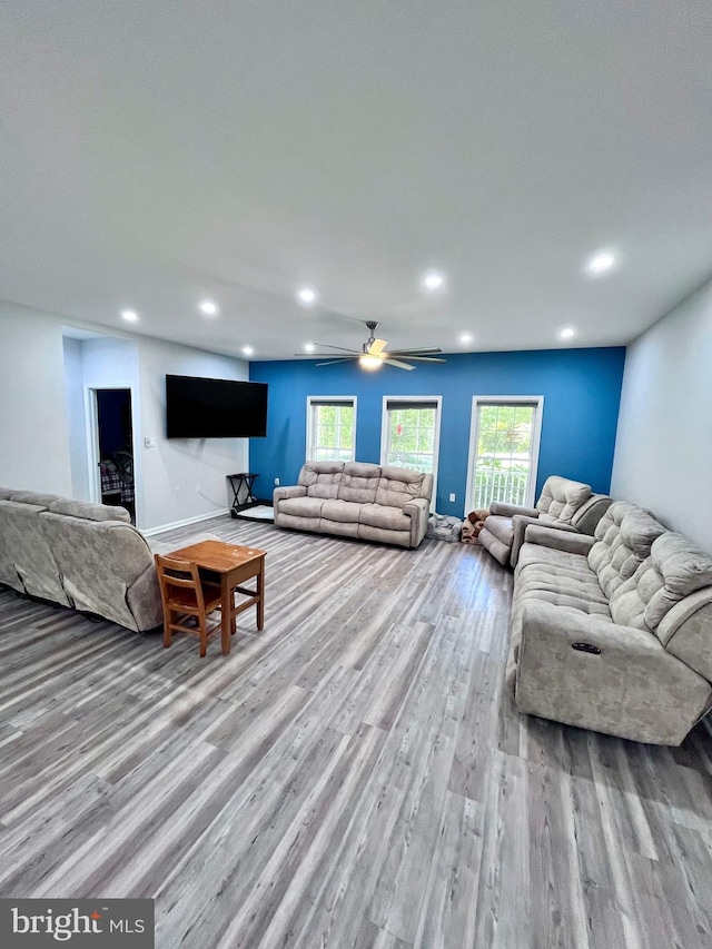 living room featuring light hardwood / wood-style floors and ceiling fan