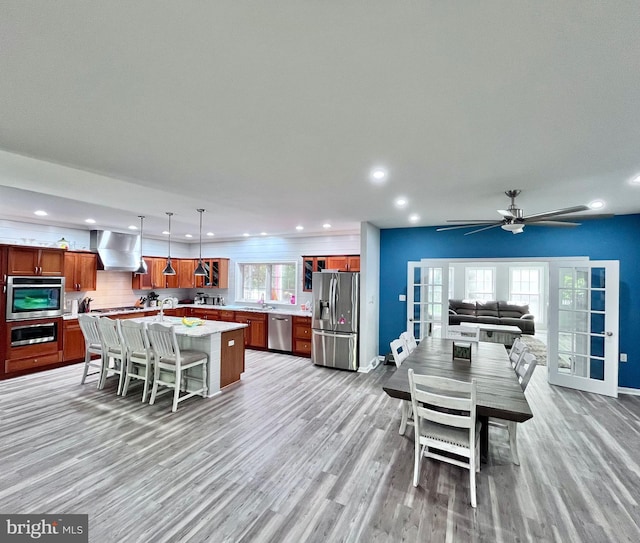 dining room featuring light hardwood / wood-style flooring, ceiling fan, a healthy amount of sunlight, and sink