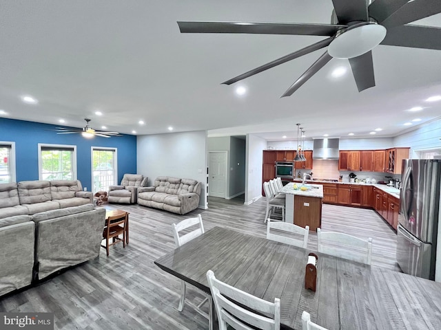 dining area featuring sink, ceiling fan, and light hardwood / wood-style flooring