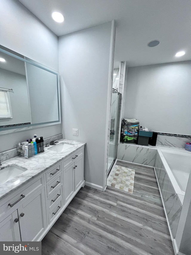 bathroom with vanity, hardwood / wood-style floors, and plus walk in shower