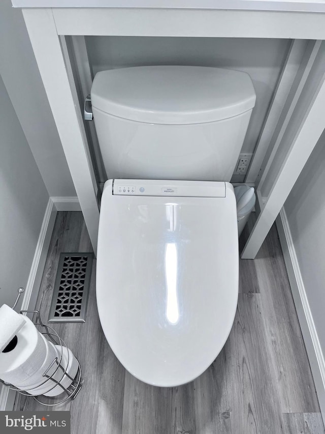 interior space featuring hardwood / wood-style floors and toilet