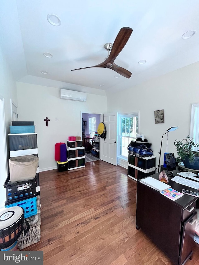 office area featuring wood-type flooring, an AC wall unit, and ceiling fan