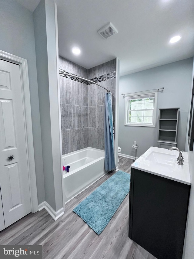 bathroom featuring vanity, hardwood / wood-style floors, and shower / bathtub combination with curtain