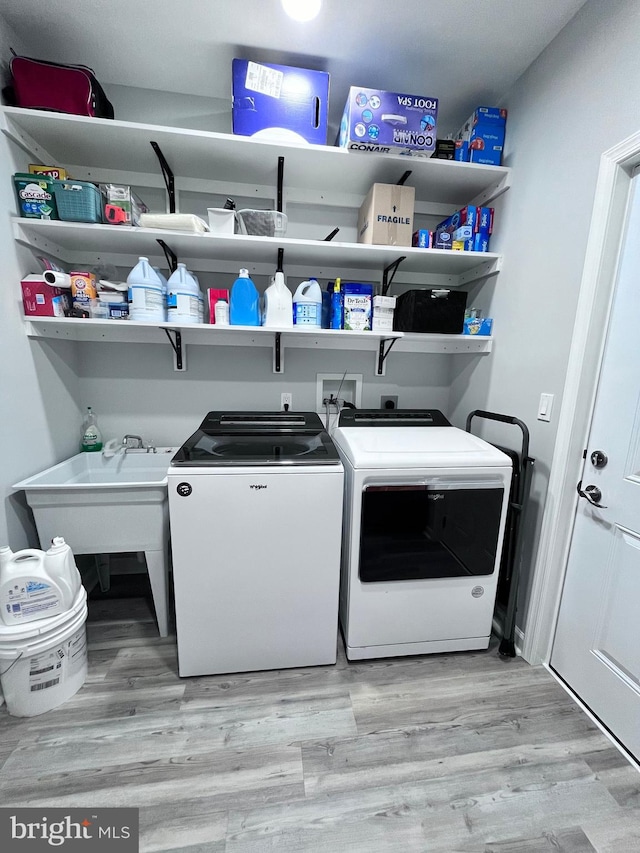 washroom with light hardwood / wood-style flooring and washing machine and dryer