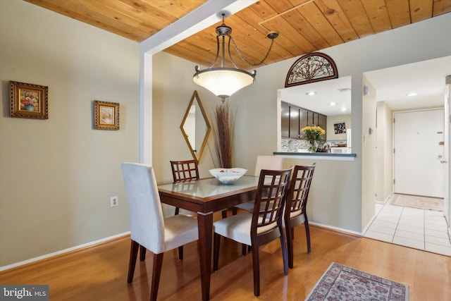 dining area with light wood-type flooring and wood ceiling