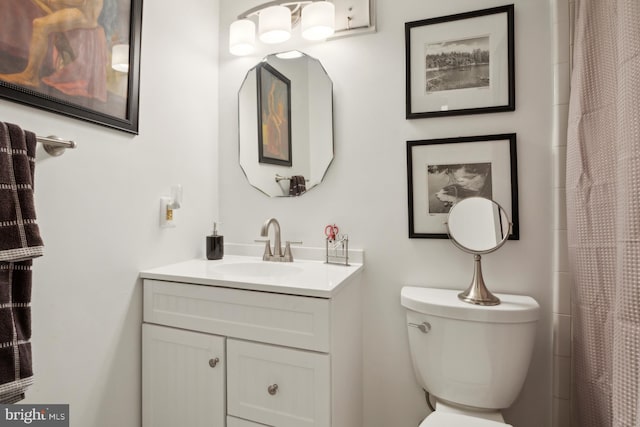 bathroom featuring walk in shower, vanity, and toilet