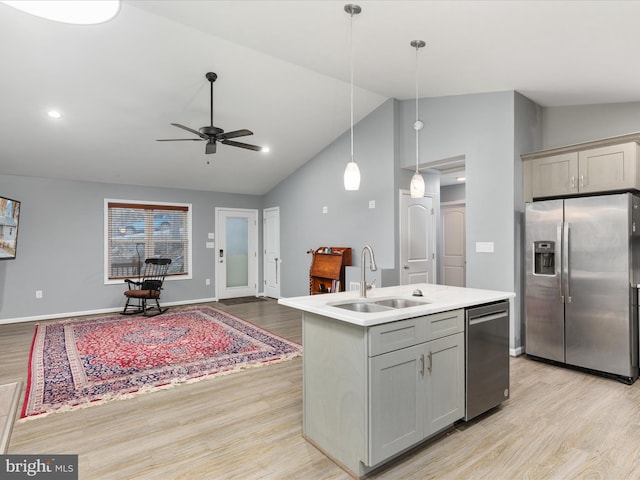 kitchen featuring gray cabinets, decorative light fixtures, stainless steel appliances, and an island with sink