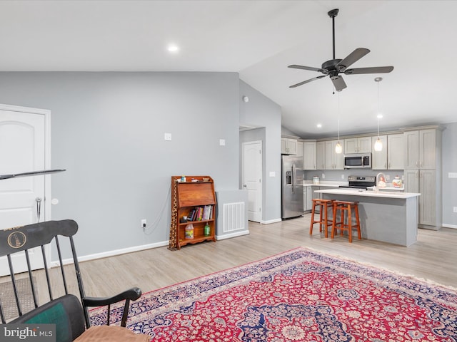 living room featuring sink, light hardwood / wood-style floors, lofted ceiling, and ceiling fan