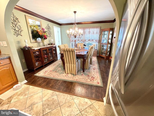 dining room featuring an inviting chandelier, light wood-type flooring, crown molding, and a healthy amount of sunlight