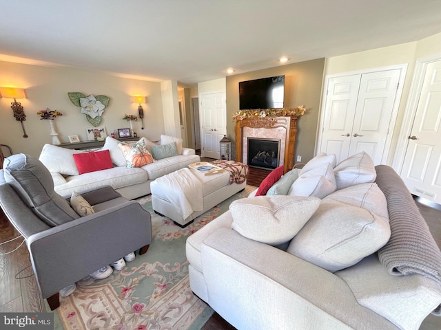 living room featuring a high end fireplace and dark hardwood / wood-style floors