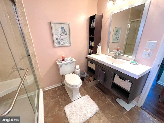 bathroom featuring vanity, tile patterned flooring, toilet, and a shower with door