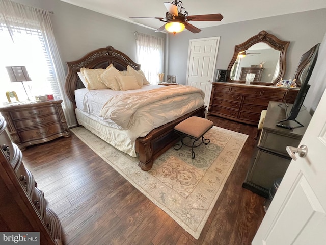 bedroom with dark hardwood / wood-style flooring and ceiling fan