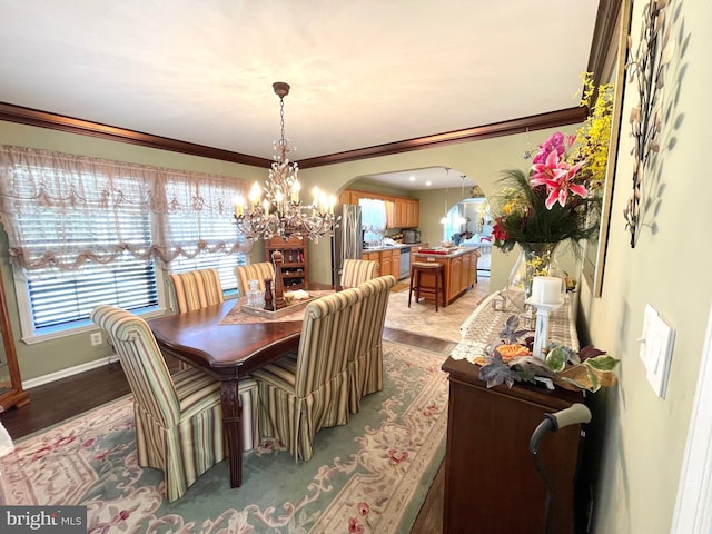 dining space with crown molding and a notable chandelier