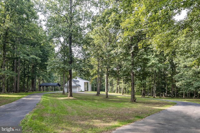 exterior space featuring a garage, a front lawn, and a carport