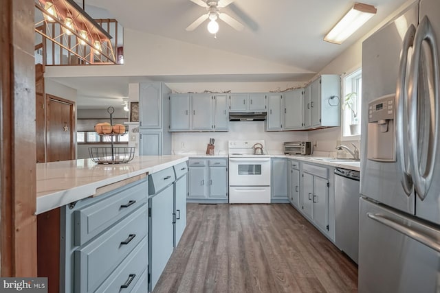 kitchen featuring a wealth of natural light, lofted ceiling, appliances with stainless steel finishes, and hanging light fixtures