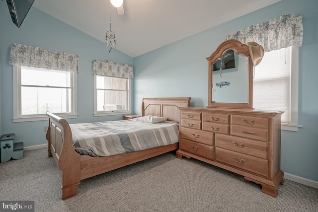 bedroom with ceiling fan, light colored carpet, vaulted ceiling, and multiple windows