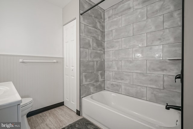 full bathroom featuring vanity, tiled shower / bath combo, toilet, and hardwood / wood-style flooring