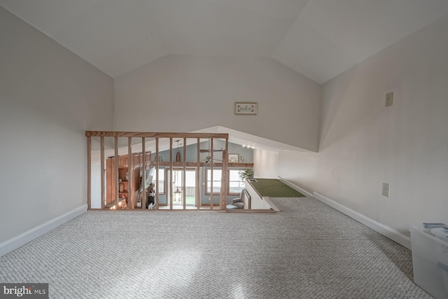 unfurnished living room with high vaulted ceiling and carpet