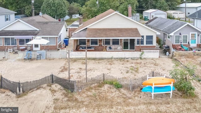 rear view of property featuring a sunroom