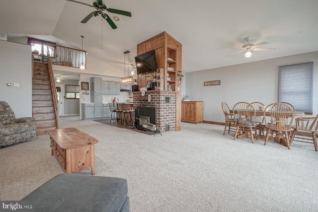 living room with light carpet, lofted ceiling, ceiling fan, and a fireplace