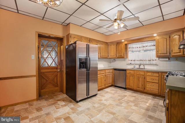 kitchen with appliances with stainless steel finishes, backsplash, ceiling fan, and sink