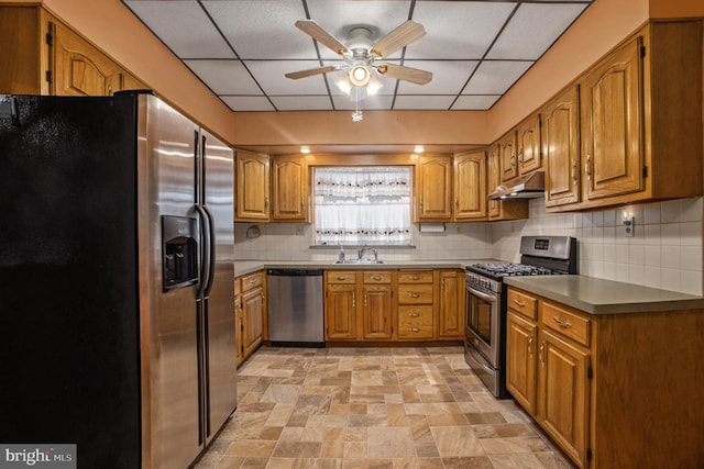 kitchen with a paneled ceiling, sink, ceiling fan, appliances with stainless steel finishes, and tasteful backsplash