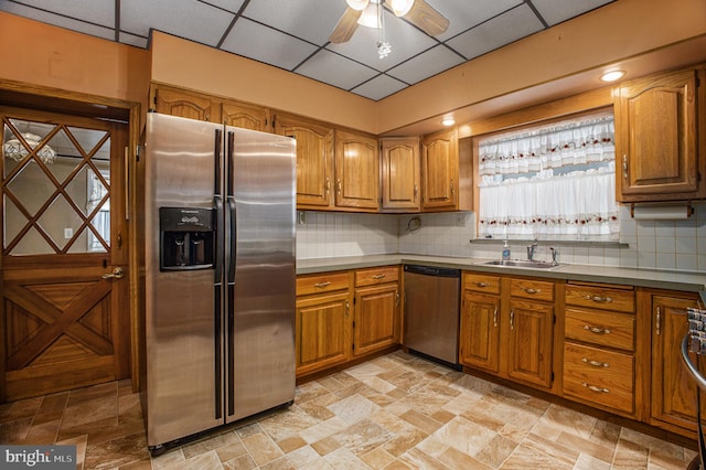 kitchen featuring a paneled ceiling, backsplash, sink, ceiling fan, and appliances with stainless steel finishes