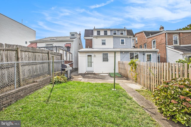 rear view of house featuring a lawn and a patio area