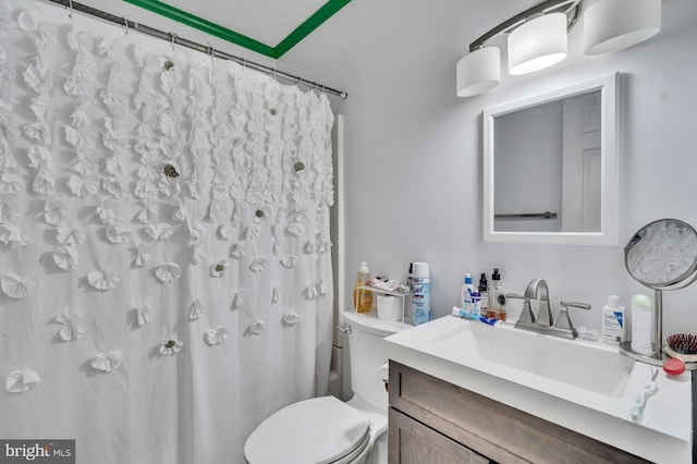 bathroom featuring curtained shower, vanity, and toilet