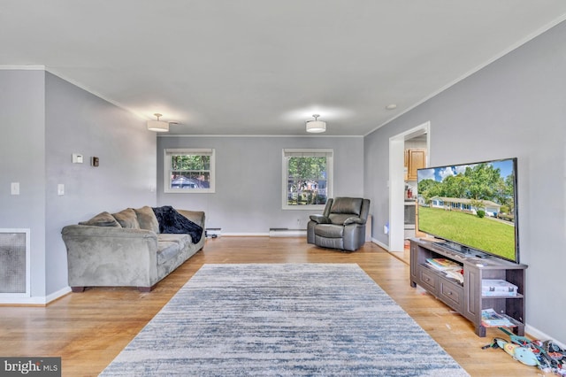 living room with light hardwood / wood-style flooring, crown molding, and a baseboard heating unit