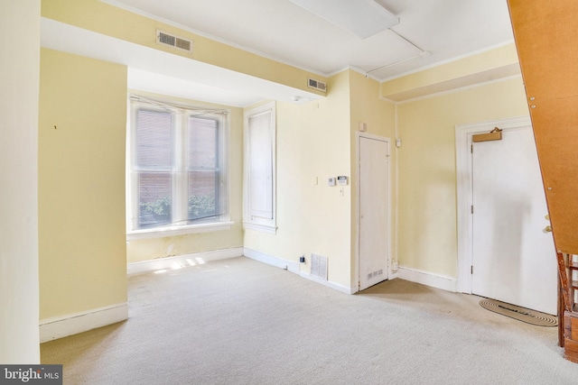 empty room with light carpet and crown molding