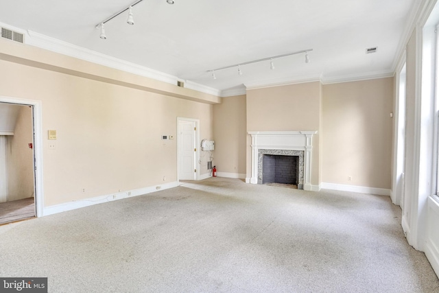 unfurnished living room featuring light carpet, crown molding, and track lighting