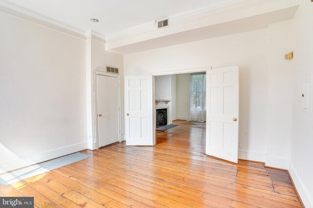 empty room featuring ornamental molding and light hardwood / wood-style floors