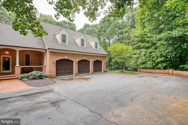 view of side of property with a porch and a garage