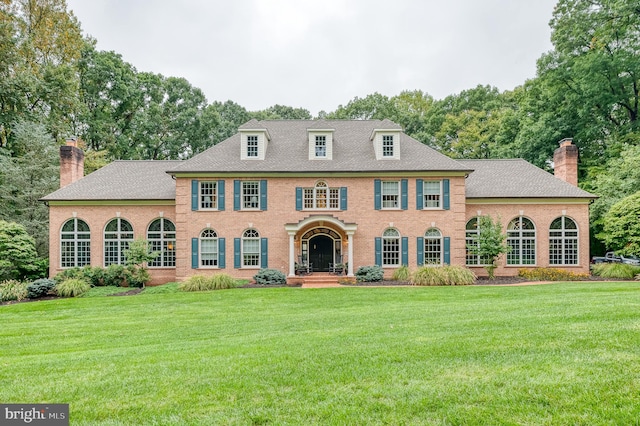 colonial inspired home with a front lawn