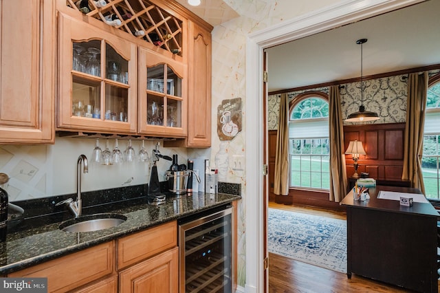 kitchen featuring sink, hanging light fixtures, dark stone countertops, wine cooler, and dark hardwood / wood-style floors