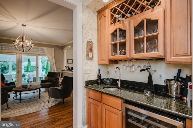 kitchen featuring sink, pendant lighting, wine cooler, an inviting chandelier, and dark hardwood / wood-style floors