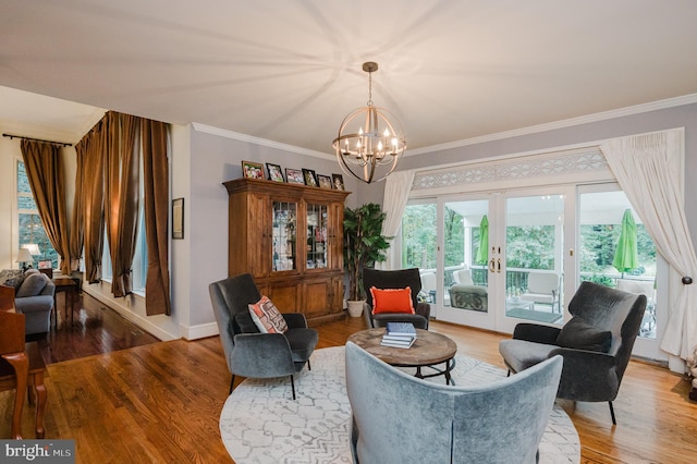 living area featuring crown molding, a notable chandelier, hardwood / wood-style flooring, and french doors