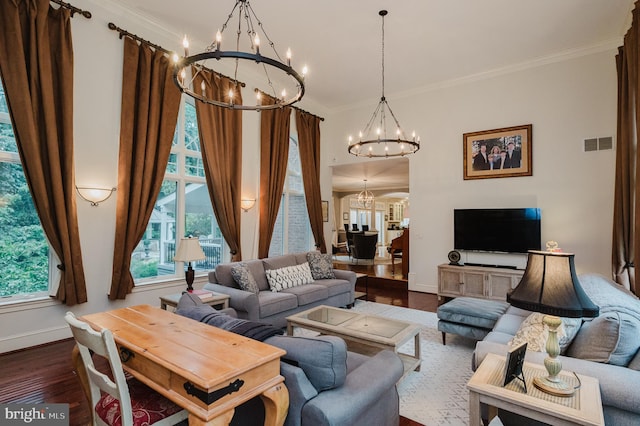 living room with an inviting chandelier, hardwood / wood-style flooring, and crown molding