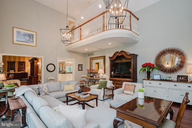 living room with a chandelier, wood-type flooring, and high vaulted ceiling