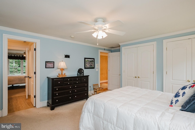 bedroom with ceiling fan, multiple closets, ornamental molding, and light carpet