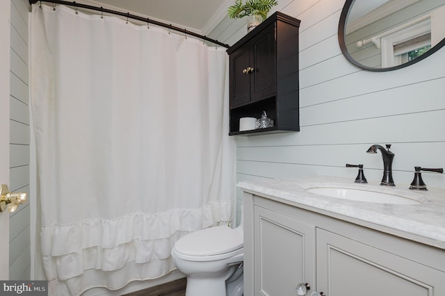 bathroom featuring vanity, toilet, a shower with curtain, and wooden walls