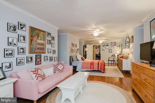 bedroom with crown molding, wood-type flooring, and ceiling fan