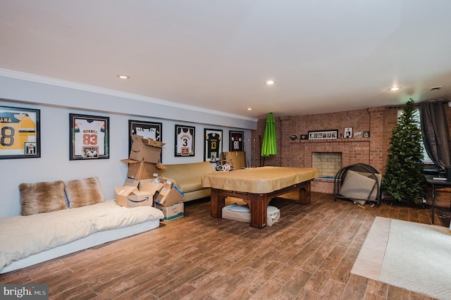 interior space with hardwood / wood-style flooring, ornamental molding, billiards, and a fireplace