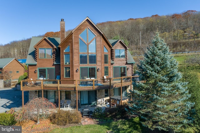 79 Cedar Shores Dr, Mc Henry, MD 21541 - back of property with a chimney, stone siding, a wooded view, log exterior, and a patio area