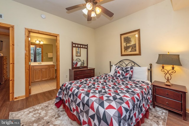 bedroom featuring ceiling fan, light hardwood / wood-style flooring, and ensuite bathroom