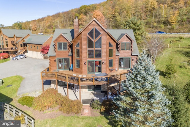 rear view of property featuring a wooden deck and a garage