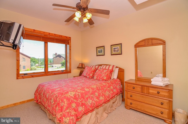 carpeted bedroom featuring an AC wall unit and ceiling fan